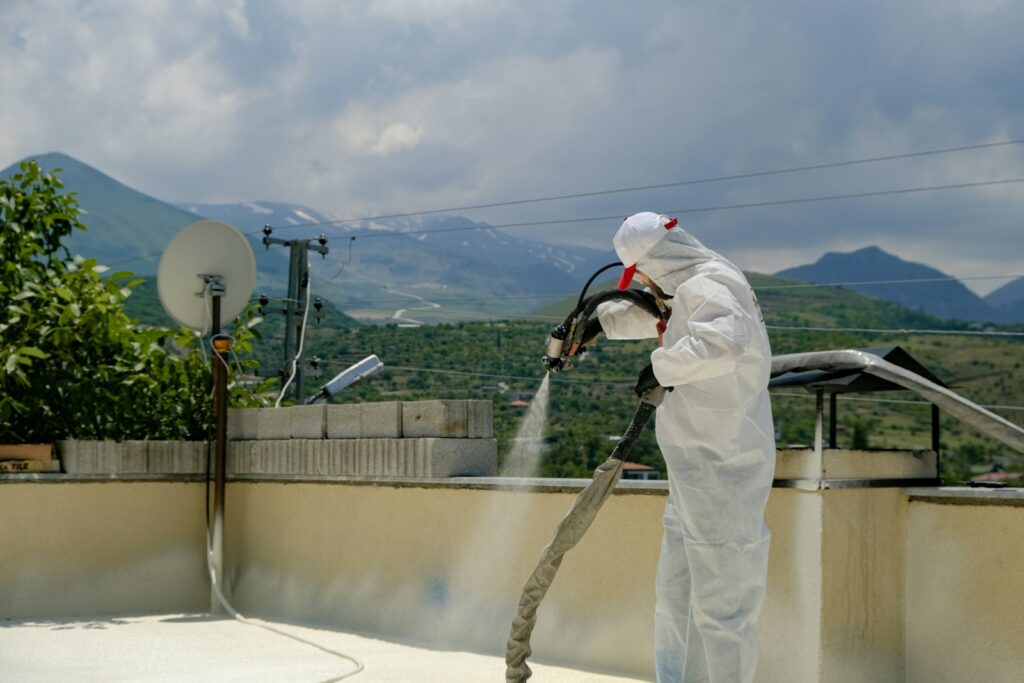 piana pur a man in a white suit spraying water on a roof