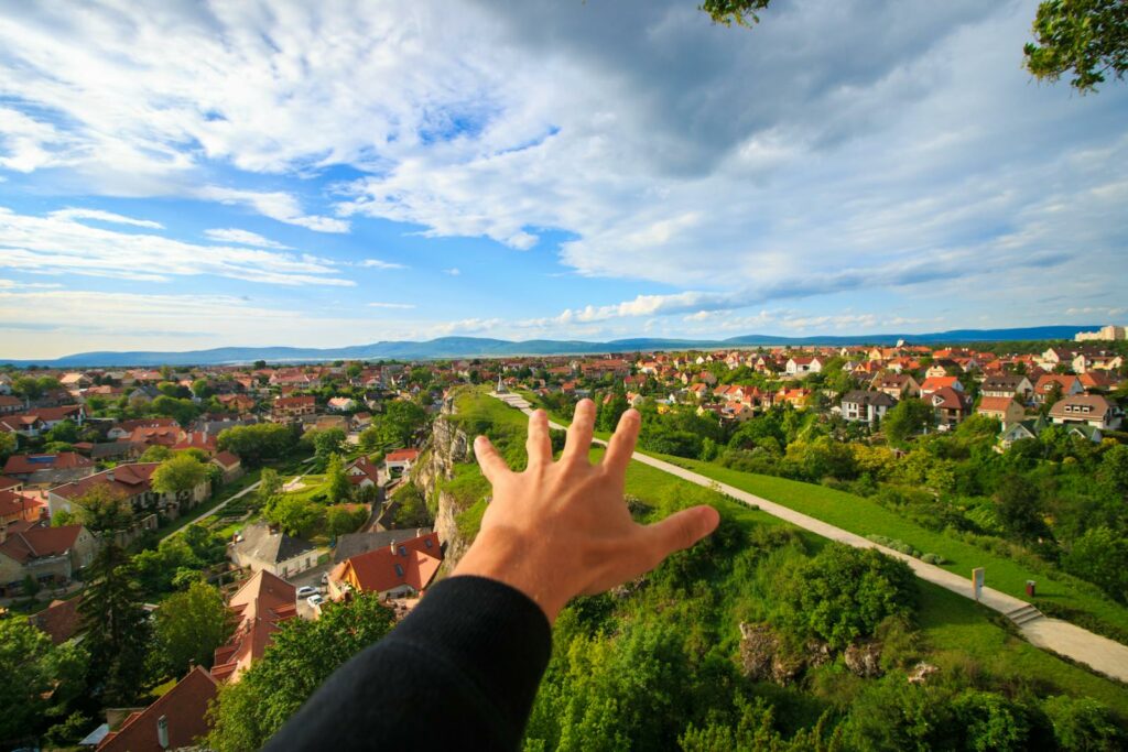 Human Hand Under White and Blue Sky on Green Grass Field czyste powietrze jakie dokumenty