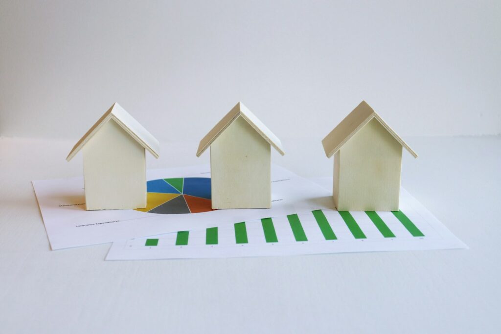 three small houses sitting on top of a piece of paper