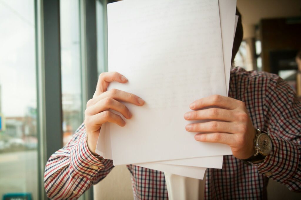 person holding white printer paper Wypełnianie wniosków Czyste Powietrze